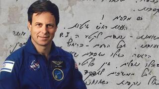 אילן רמון על רקע אחד מדפי היומן ששרדו